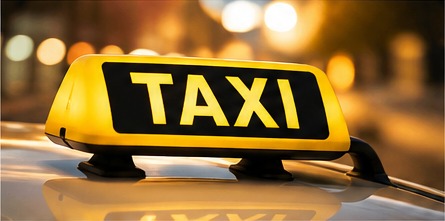 Leuchtendes TAXI-Schild auf einem Fahrzeug bei Abendlicht